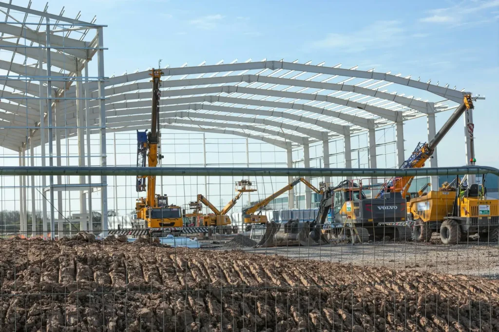 Nave industrial en construcción con estructura metálica y maquinaria
